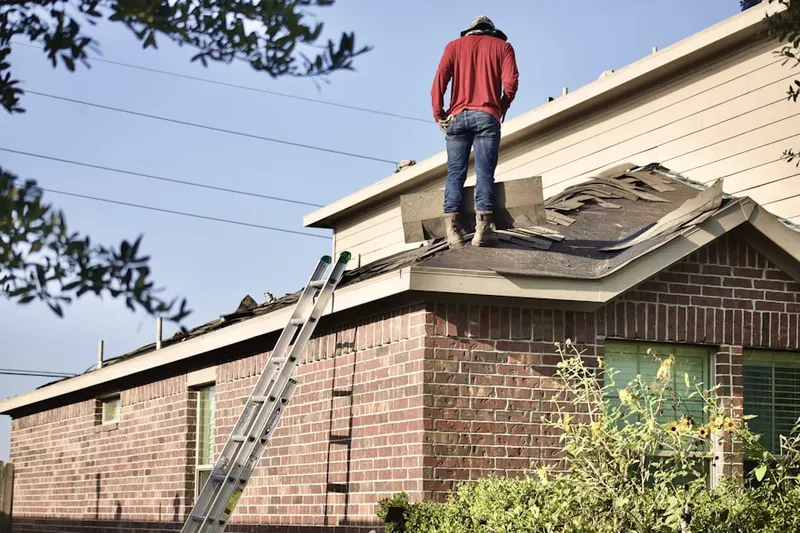 Professional roofer working on a residential roof in Applewood West